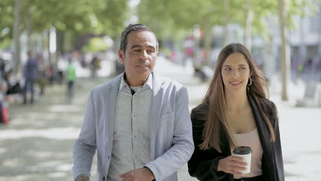 Male-and-female-colleagues-talking-outdoor