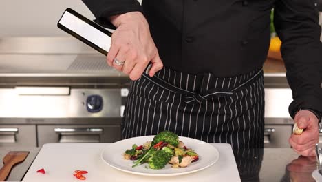 chef drizzling olive oil over a healthy chicken and vegetable dish