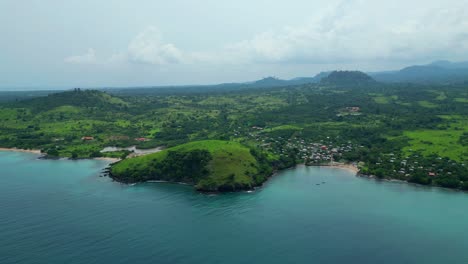 flying towards morro peixe village and beach with fishing boats anchored at bay.sao tomé e principe,africa