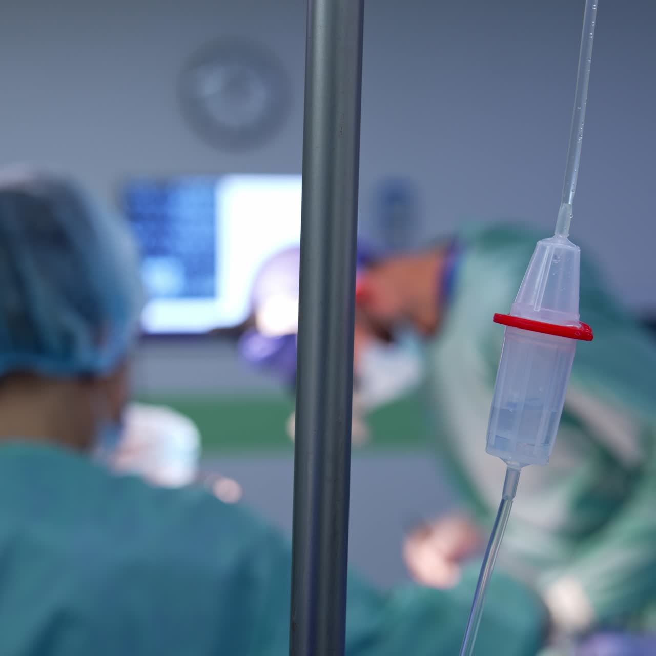 Drop counter for intravenous injections close up. Medics in uniform working in surgery room at backdrop in blur