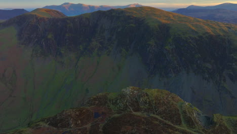 dark mountain valley with pan up revealing mountains lit by autumnal dawn sunlight