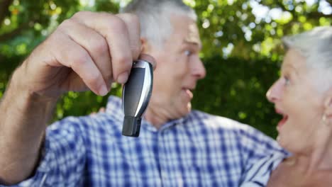 Senior-man-showing-car-key-to-senior-woman