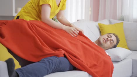 la mujer que cubre a su marido durmiendo. una pareja feliz.
