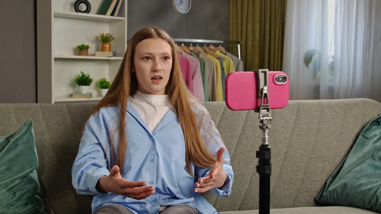 Teenager vlogging on sofa at home