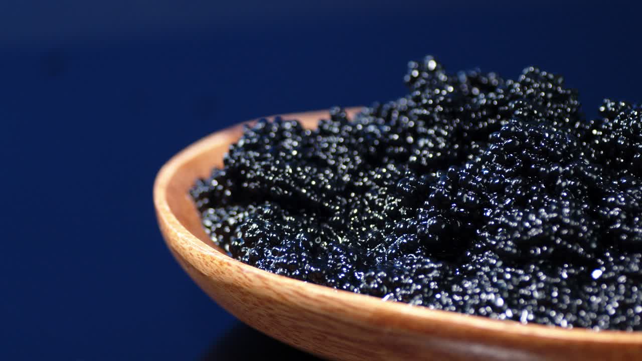 A plate of black caviar rotates slowly.