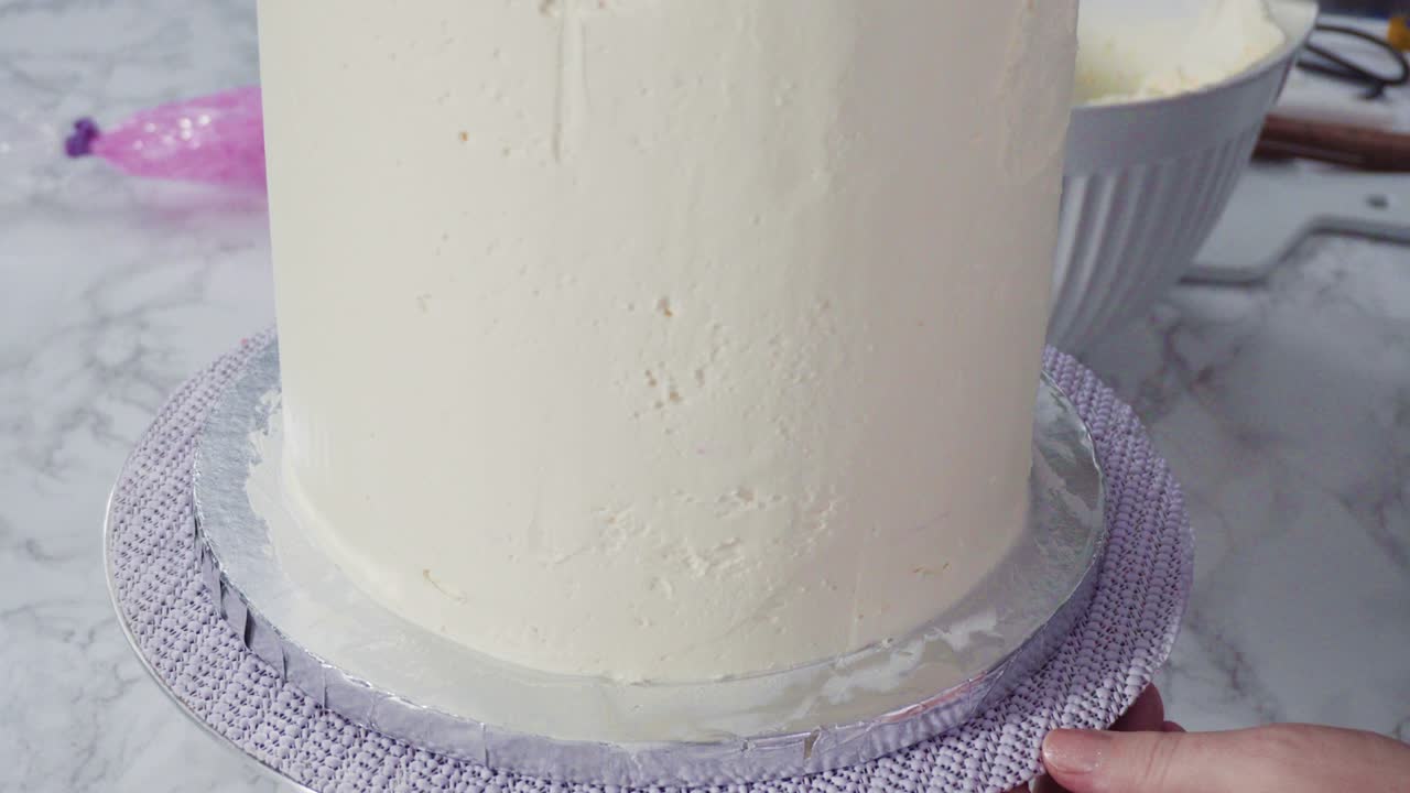 Frosting round funfetti cake with white italian buttercream frosting.