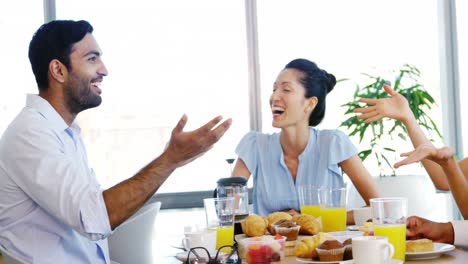 business colleagues interacting with each other while having breakfast