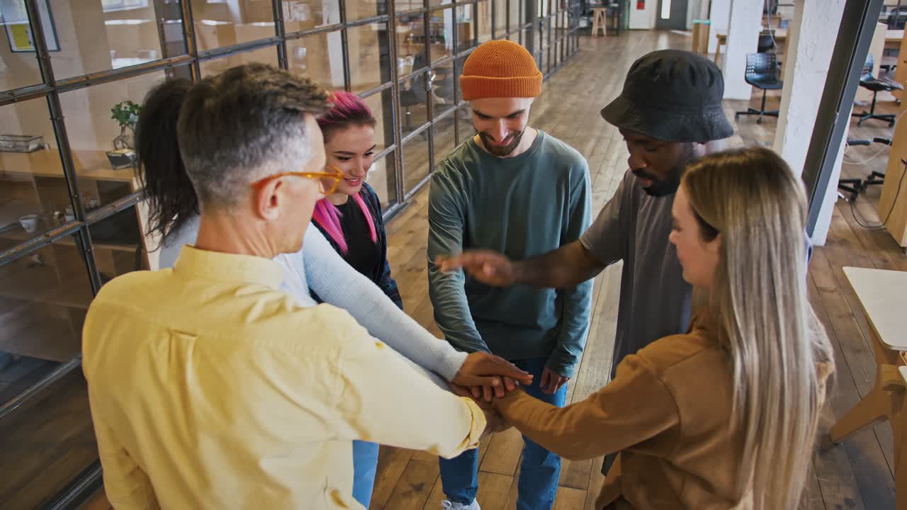 amistad en la oficina. equipo creativo multiétnico joven y alegre que une las manos, concepto de formación de equipo
