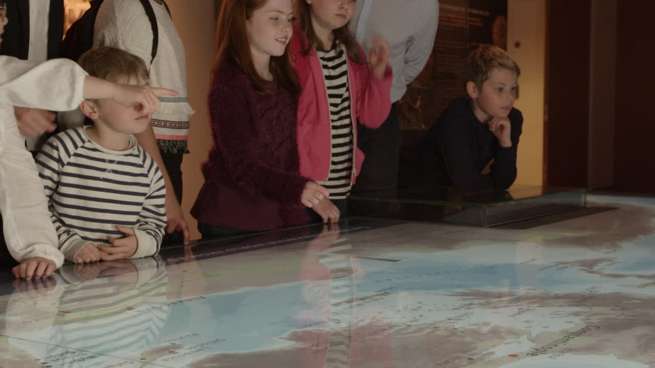 учащиеся на школьной экскурсии в музей смотрят карту, снятую на r3d