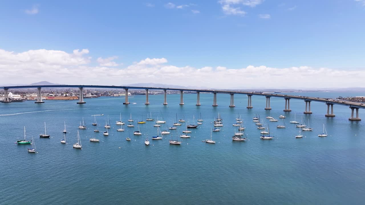 Aerial pan around Mooring sailboats next to Coronado Bridge in San Diego Bay