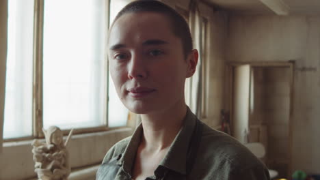 portrait of young female sculptor in workshop