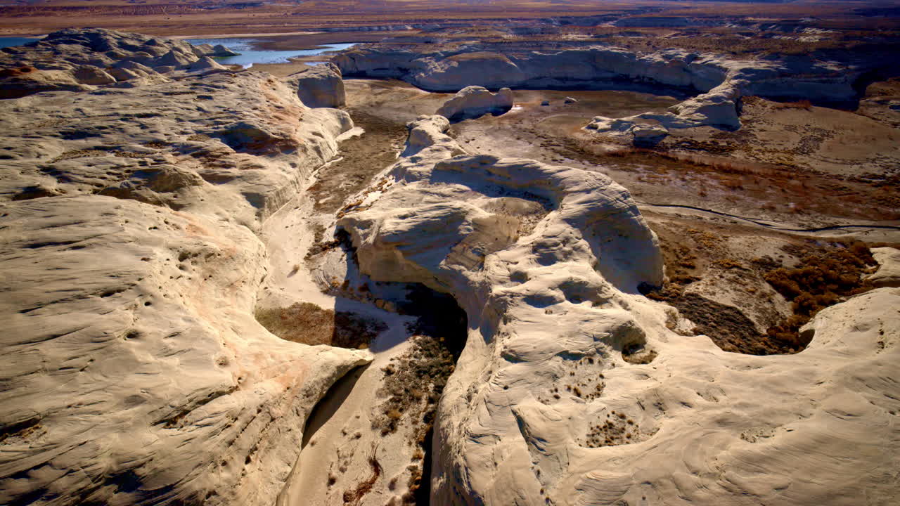 A drone travels toward intriguing rock formations by Lake Powell in Page, Arizona.