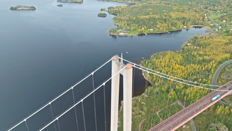 aerial view of concrete pylon of the suspension bridge of hogakustenbron above colorful trees in sweden