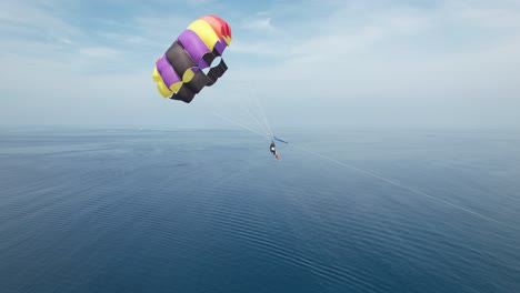 happy honeymooner couple parasailing in the maldives, drone closeup