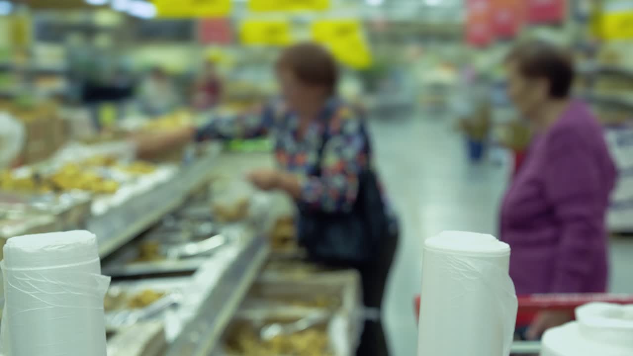 dos mujeres mayores en un supermercado están recogiendo