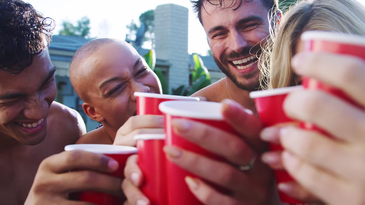 grupo de amigos con bebidas al aire libre relajándose en la piscina y disfrutando de la fiesta de la piscina de verano