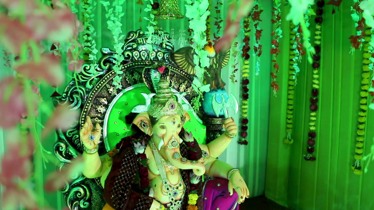 Beautiful Ganpati idol in vibrant pandal adorned with flowers and colorful lights. Perfect for videos on Indian festivals, culture, spirituality, religious celebrations and Ganesh Chaturthi joy.