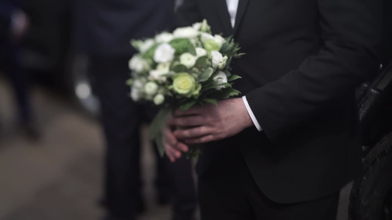 Lo sposo con il bouquet di nozze