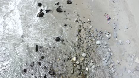 Stetig-Kippender-Flugwagen-Aus-Der-Luft-Von-Dana-Points-Beach-Mit-Felsiger-Küste-Und-Vielen-Menschen,-Die-Die-Dramatischen-Klippen-Und-Tosenden-Wellen-Genießen