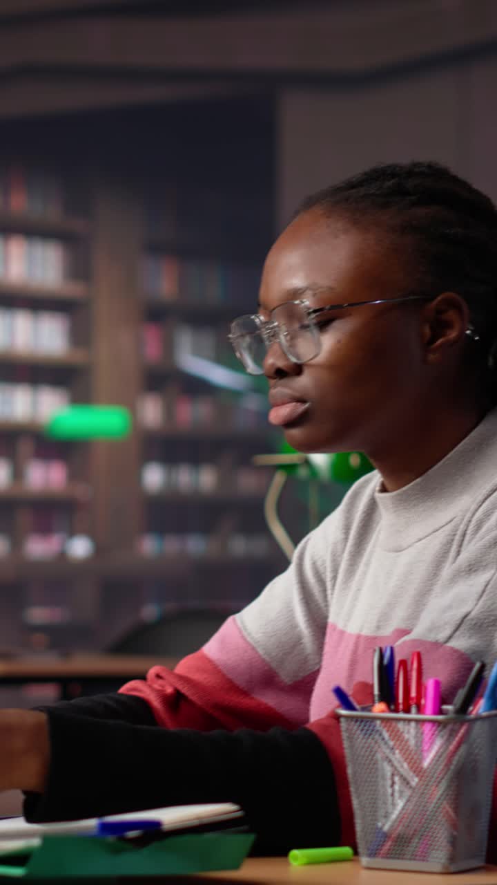 Vertical video university student engrossed in texting with classmates at the library
