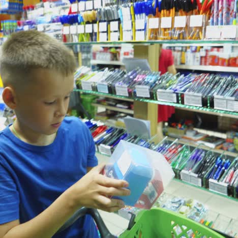 vinnitsa, ukraine - august 20, 2018: beautiful boy choosing school stationery at a supermarket. shopping for school