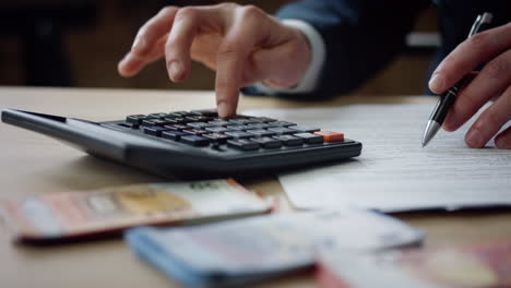 Closeup-man-using-calculator-counting-budget.-Male-hands-pressing-buttons.