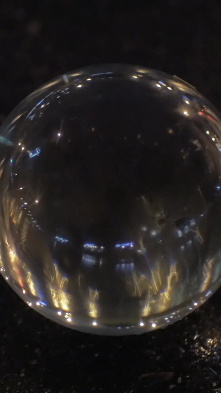 Vista di una sfera di vetro che riflette le luci della città