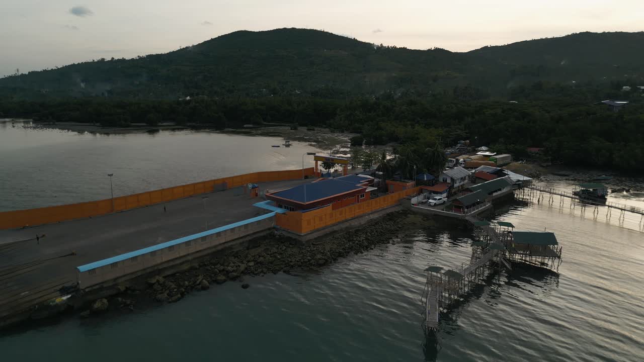 fotografía aérea del puerto de taloot argao en cebu, filipinas, que muestra las instalaciones portuarias y los barcos amarrados al amanecer con la zona de carga de transbordadores vacía