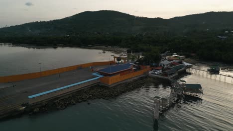 aerial dolly shot of taloot argao port in cebu, philippines, showcasing the port facilities and moored boats at sunrise with empty ferry loading zone