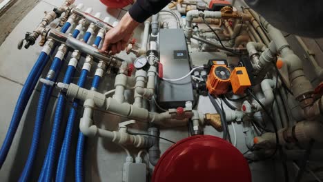 fontanero profesional. servicio de reparación de tuberías. reparador arreglando un calentador de agua de gas con un destornillador. manos de trabajador arreglando el sistema de calefacción