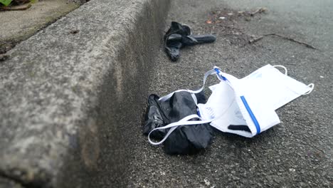 더럽게 버려진 코로나 바이러스 마스크와 장갑은 복사 공간이 오른쪽으로 내려가는 바람에 보도에 깔려 있습니다.