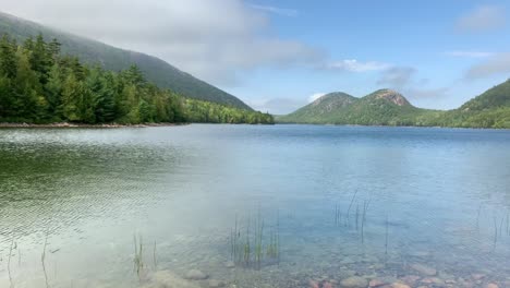 4k lady contemplates while looking over beautiful jordan pond in acadia national park in maine