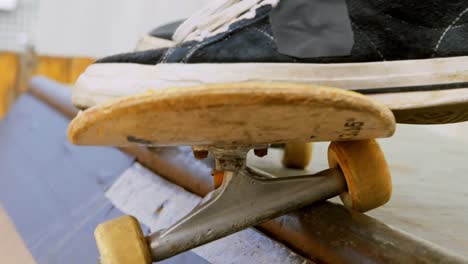 primer plano de un joven haciendo un truco de skateboard en el borde de la rampa de skateboard en la cancha de skateboard 4k
