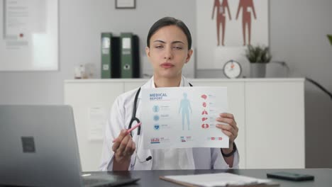 indian female doctor explaining medical report to patient