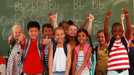 Smiling-kids-showing-thumbs-up-in-classroom