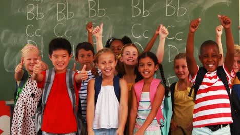 niños sonrientes mostrando los pulgares en el aula