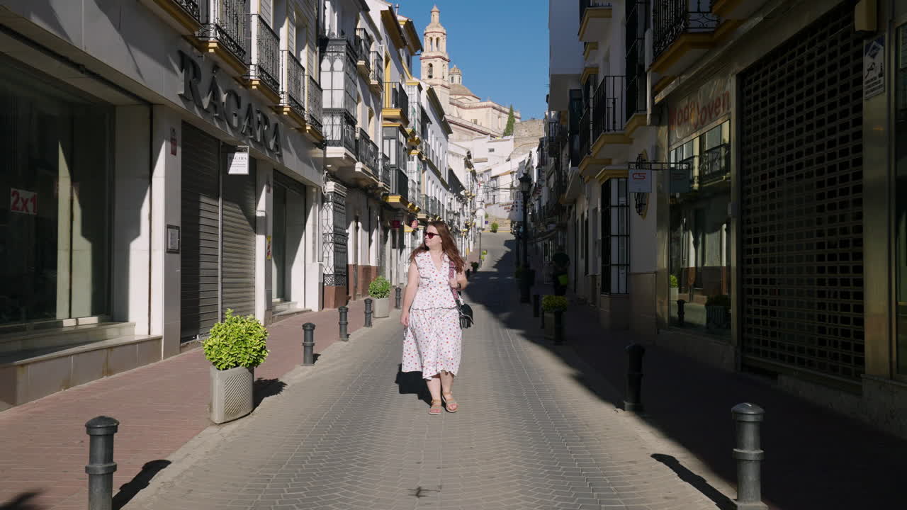 Kvinnelig turist går i den tomme gaten i Olvera by i Cádiz, Andalusia, Spania.