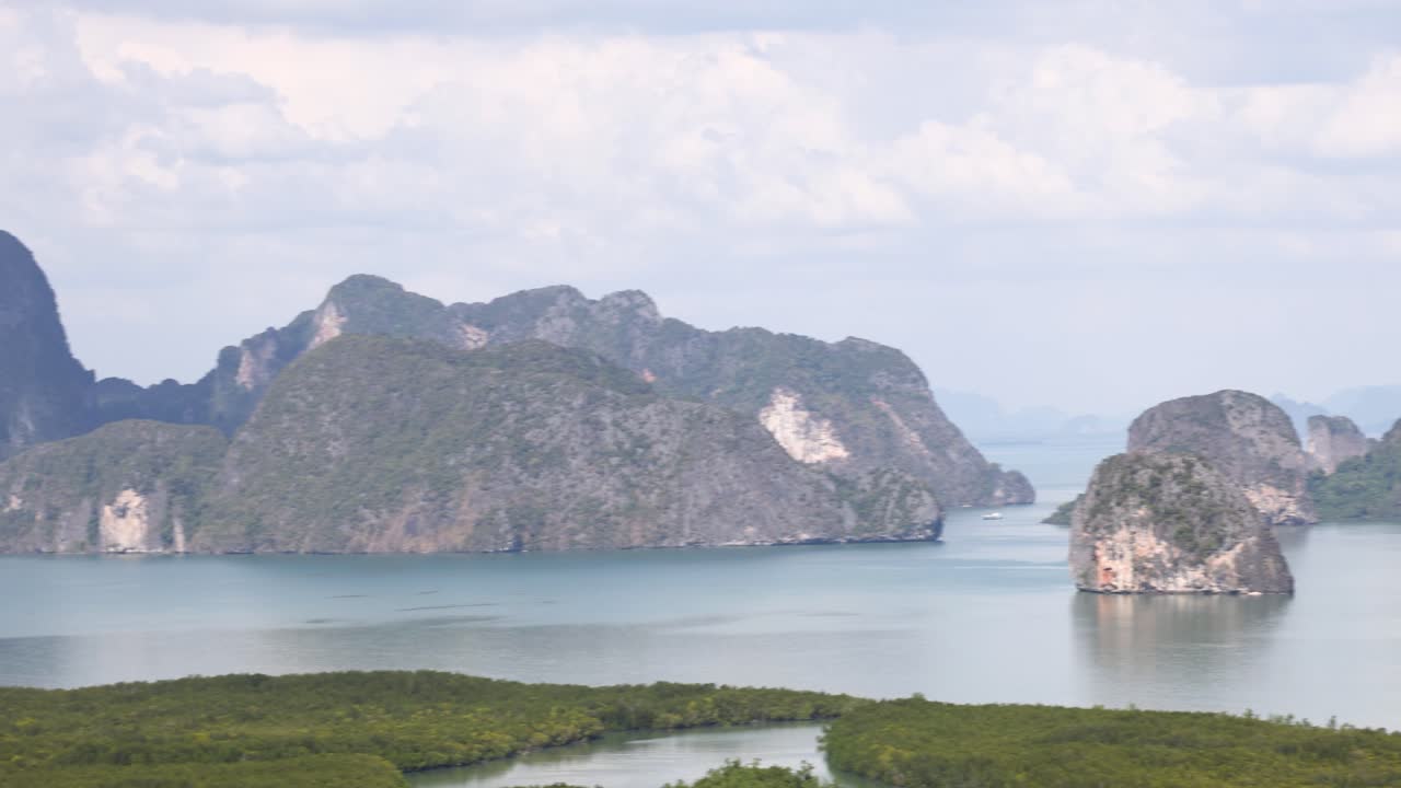 Aerial footage captures the stunning limestone karsts and lush greenery of Phang Nga Bay under clear skies