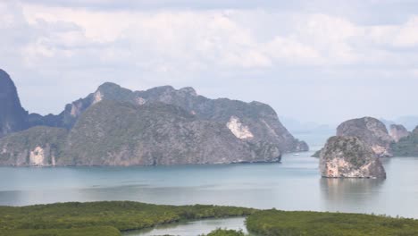 aerial footage captures the stunning limestone karsts and lush greenery of phang nga bay under clear skies