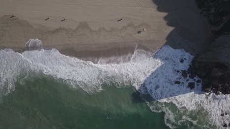 Drone-head-shot-of-sea-water-waves-hits-beachside
