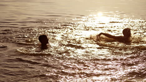 joyful children playing with water at sunset. young boys having fun in the river. two brothers splashing in water in the evening.