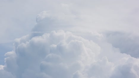 cloudscape time lapse view of white fluffy clouds moving in the wind over a blue sky