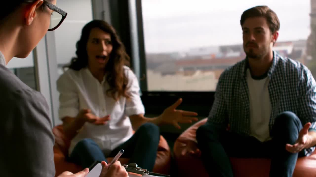 pareja hablando con un consejero matrimonial durante la terapia