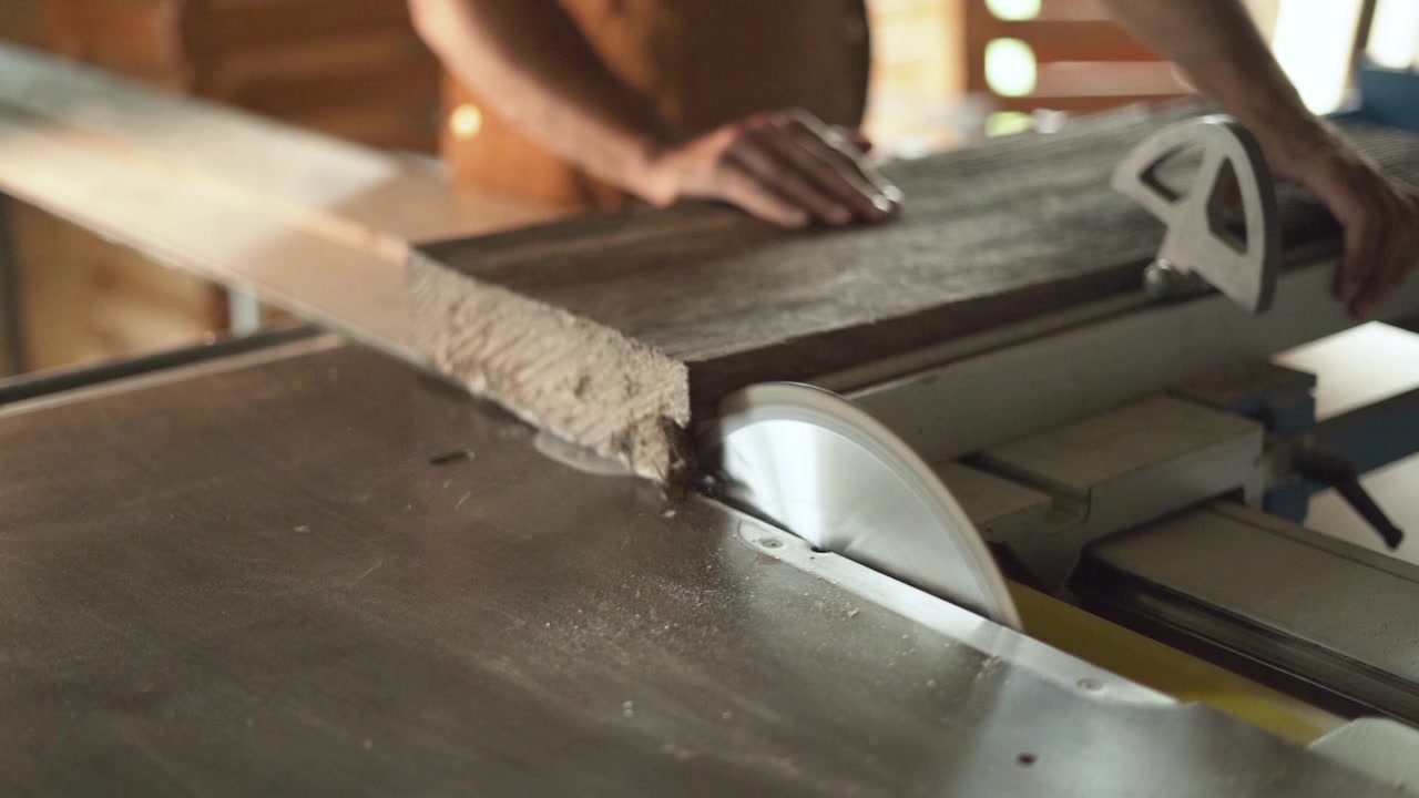 Un operaio di segheria taglia il legno con una sega circolare al rallentatore. La capacità della lama determina la profondità massima di taglio che una sega può raggiungere. Più grande è la lama, più profondo è il taglio.