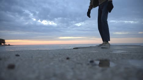 Pies-De-Hombre-Con-Zapatos-Caminando-Por-La-Playa-De-Arena-Con-Fondo-De-Cielo-Nublado---Disparo-De-Bajo-Nivel