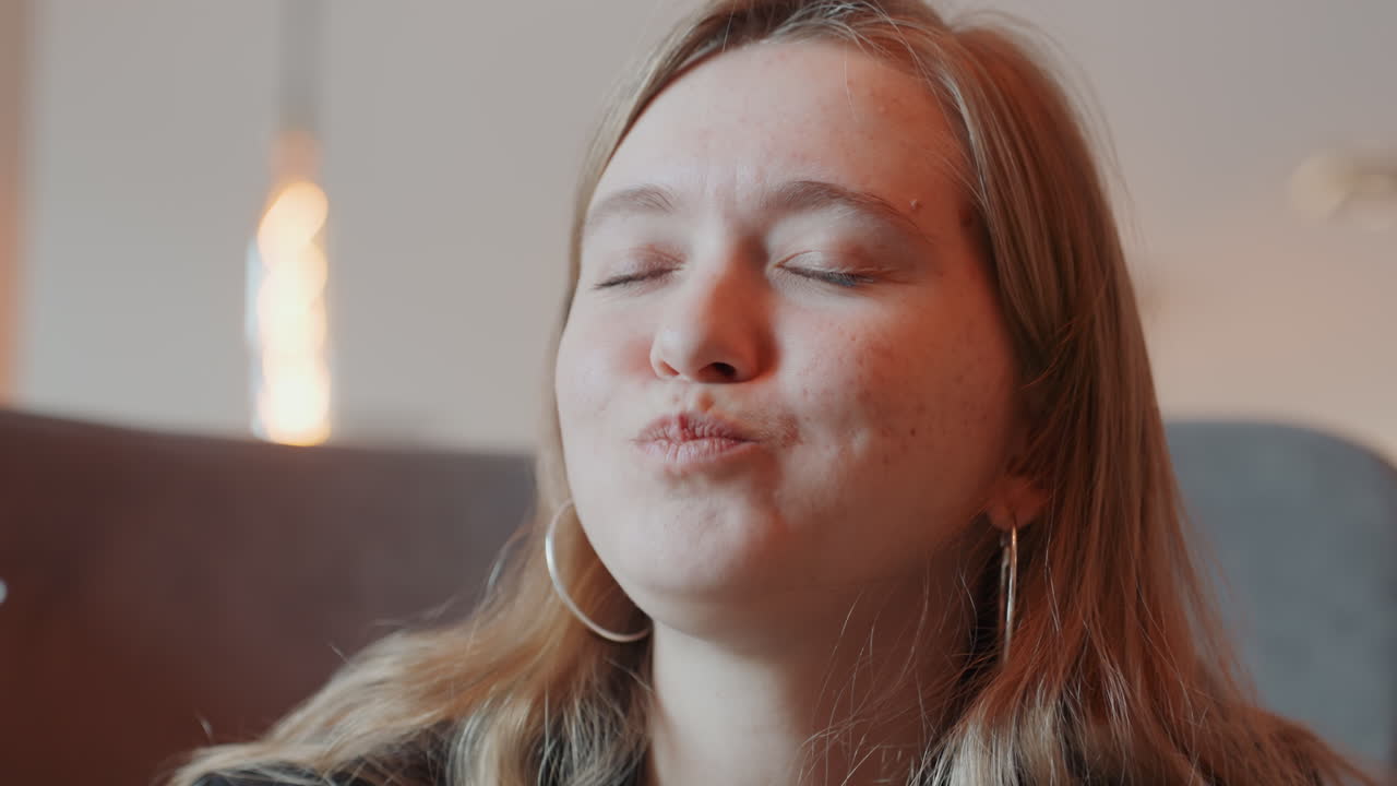 Donna caucasica che assapora un pomodoro sulla forchetta, occhi chiusi e sorriso delicato, illuminazione interna soffusa, momento sensoriale ravvicinato, pomodoro rosso fresco, atmosfera rilassata e accogliente da caffè, ritratto spontaneo di cibo.