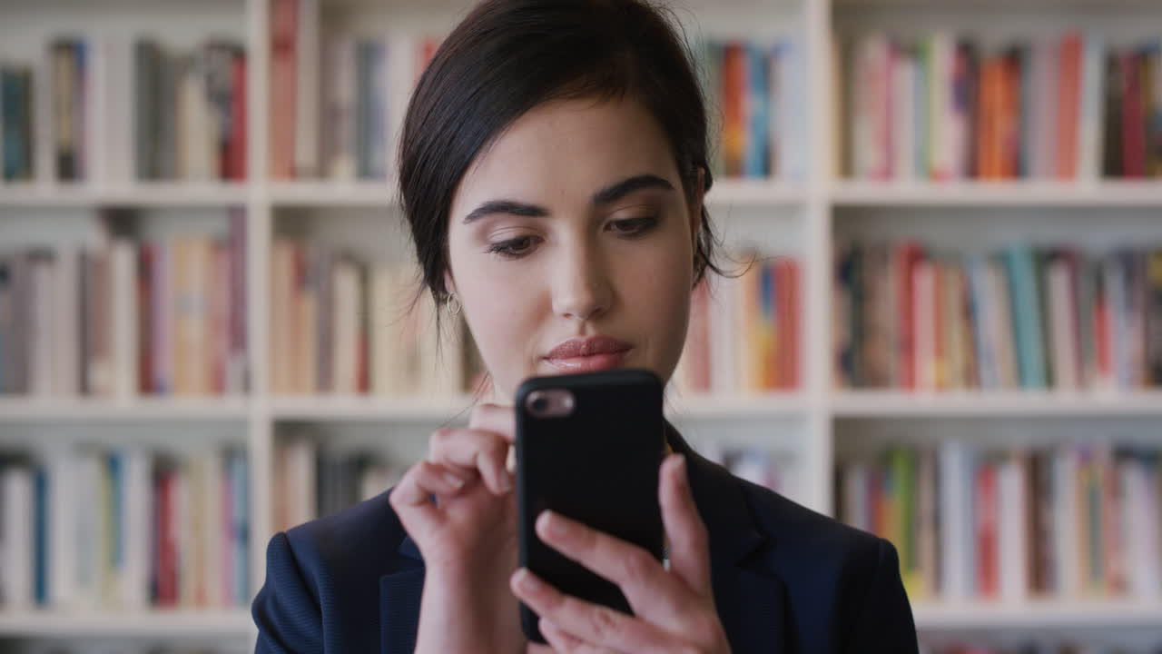 retrato de una hermosa joven mujer de negocios usando un teléfono inteligente navegando en línea leyendo mensajes de texto en un teléfono móvil en cámara lenta