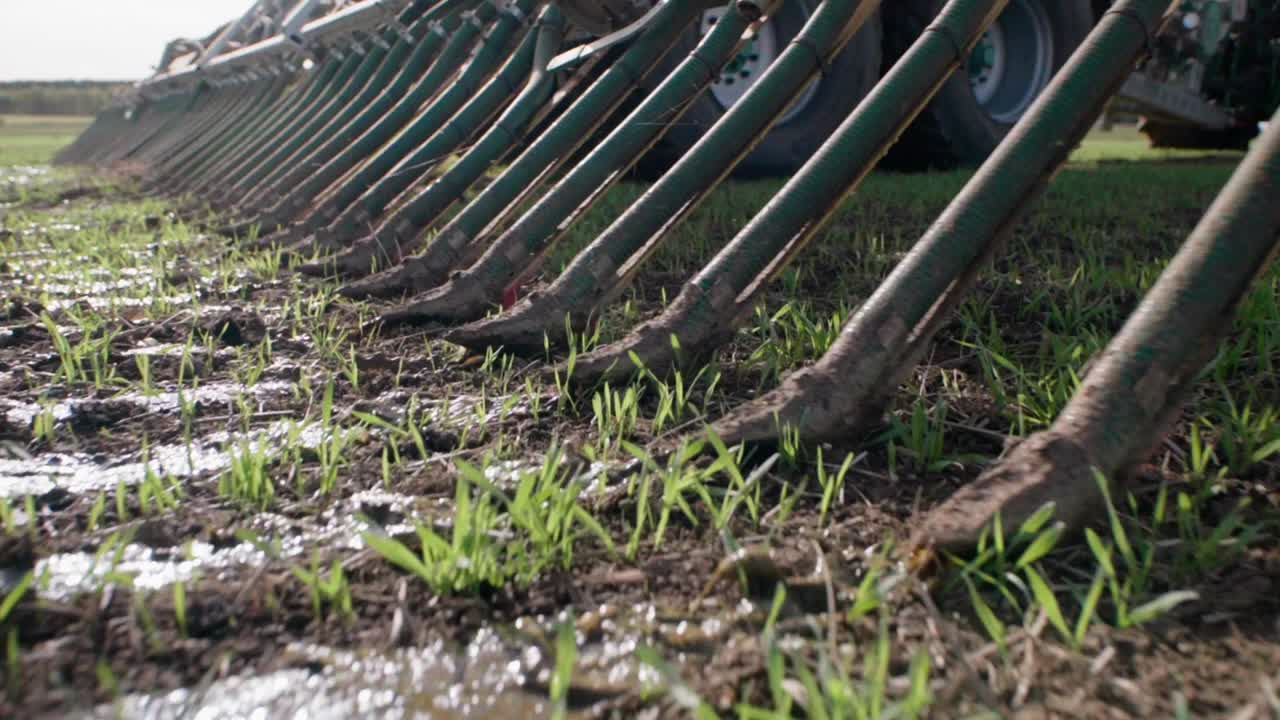 esparcidor de estiércol líquido que libera lodo en el campo de cerca en cámara lenta