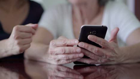 Cropped-shot-of-mature-women-using-smartphone.