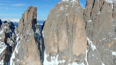 Disparo-épico-De-Un-Dron-Que-Muestra-Una-Formación-Rocosa-De-Fassa-Nevada-En-La-Cumbre-De-Los-Dolomitas-Durante-La-Luz-Del-Sol